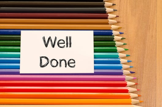 Blank white paper and colored pencil on wooden background