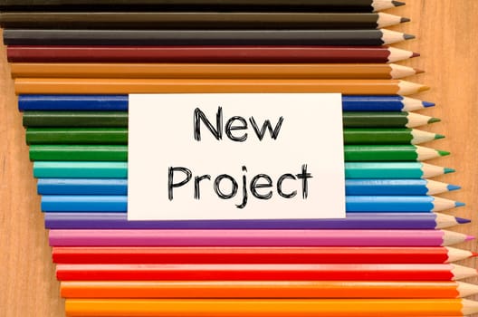 Blank white paper and colored pencil on wooden background
