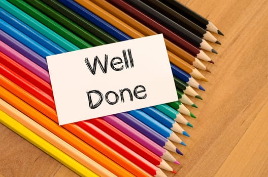 Blank white paper and colored pencil on wooden background