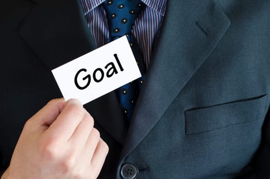 Goal text note concept over business man background.