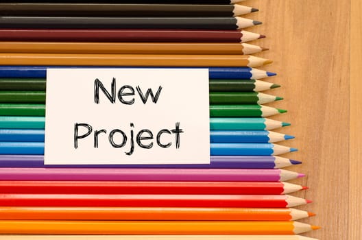 Blank white paper and colored pencil on wooden background