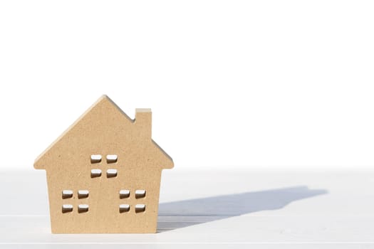 Miniature model of house on table, white background