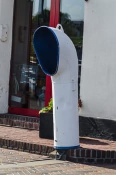 Marine equipment for ventilation and venting of ship interiors in front of a house wall.