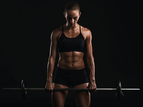Shot of a beautiful young woman in a workout gear lifting weights