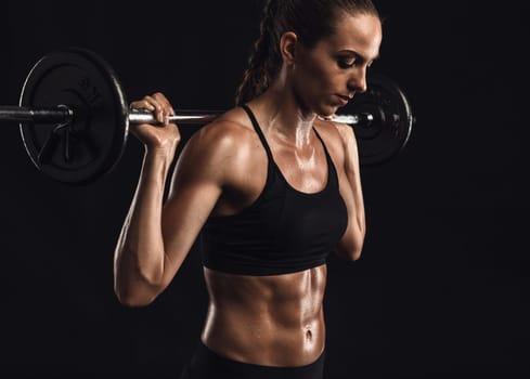 Shot of a beautiful young woman in a workout gear lifting weights
