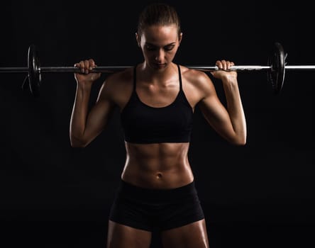 Shot of a beautiful young woman in a workout gear lifting weights