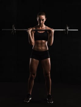 Shot of a beautiful young woman in a workout gear lifting weights
