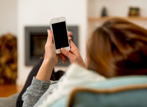 Beautiful woman at home sending text messages