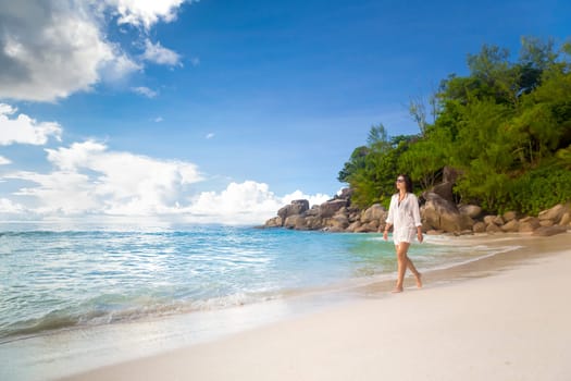 Beautiful woman walking in the beautiful beach of Praslin, Seychelles