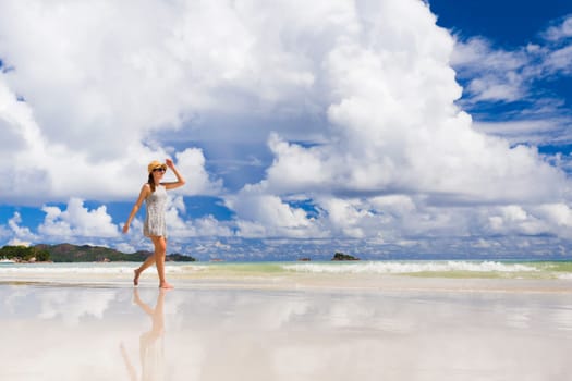 Beautiful woman walking in the beautiful beach of Praslin, Seychelles
