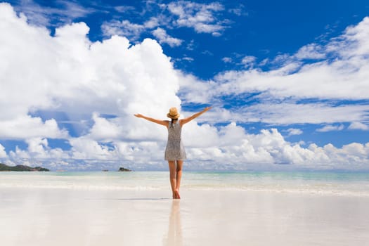 Beautiful woman walking in the beautiful beach of Praslin, Seychelles