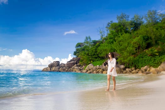 Beautiful woman walking in the beautiful beach of Praslin, Seychelles