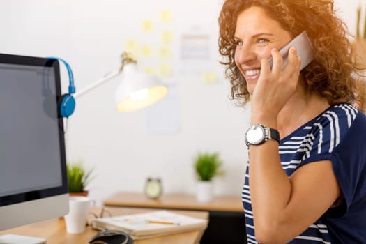 Middle aged woman at office making a phone call