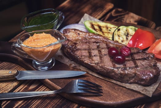 grilled beef steak with sauce and vegetables
