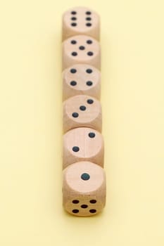 Wooden dice in a row on yellow background