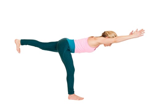 Lateral full-body view of a young woman during yoga exercise "the Warrior 3"" (Virabhadrasana III) against a white background with a slight shadow"