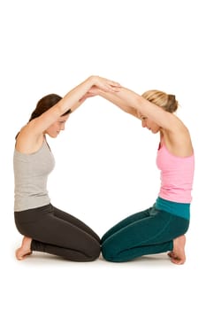 Full body view of two young women in sports dress depicting the letter O on a white background.