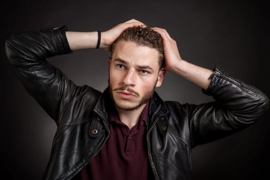 Young handsome man in black leather jacket. looking aside