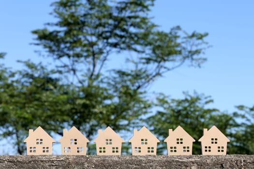 Miniature model of house with tree and sky background