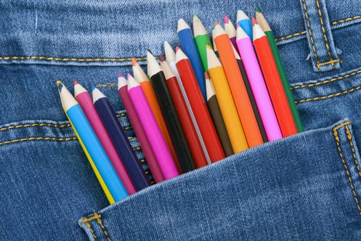 Pocket jeans and a group of colorful drawing pencils