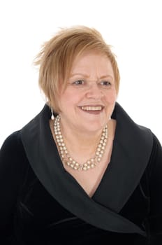 A smiling senior woman in a black dress smiling in a portrait image,.wearing a peal necklace, isolated for white background..