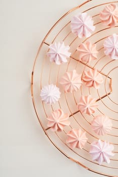 Pastels colored meringue kisses on cooling rack overhead view