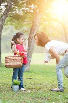 Lifestyle portrait mom and daughter in happiness at the outside in the meadow, family outdoor fun, morning with sun flare.