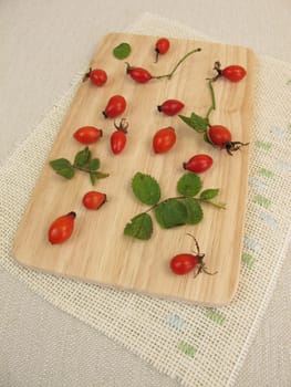 Wild fruits rose hips on a wooden board