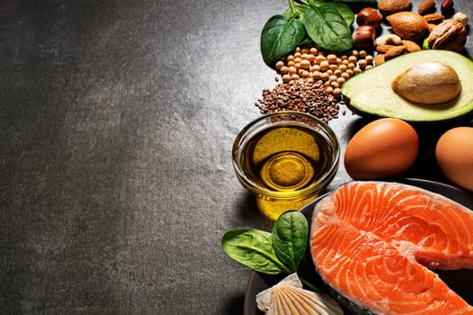Selection of healthy food. Raw steak of salmon with fresh ingredients on gray background.
