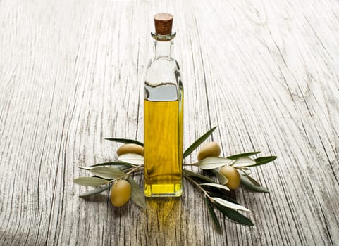 Olive oil and olive branch on the wooden table