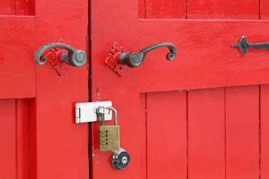 closeup of old wooden red door with padlock