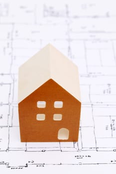 Wooden model of house on blueprints