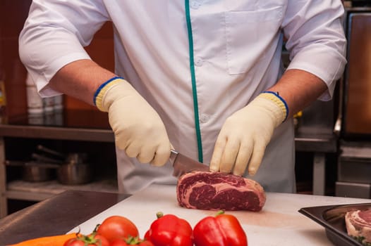 Chef cutting meat on steaks with knife