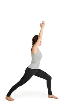Full-body view of a young black-haired woman during the yoga exercise "peaceful warrior"" (Varabhadrasana) against a white background with light shadows"