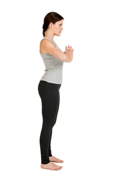 Full-body view of a young black-haired woman during yoga exercise "Standing Prevention"" Step 1 against a white background with a slight shadow"