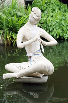 Statue in a pond boy playing a flute