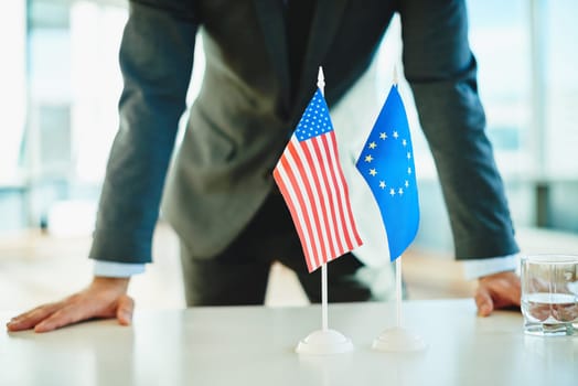 American flag and flag of European Union with businessman near by