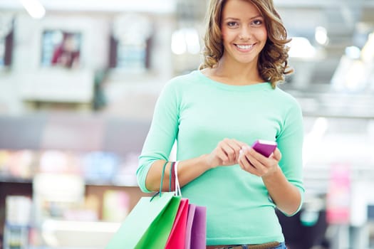 Cute female with shopping bags and cellphone