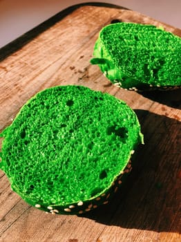 Exotic green burger in a soft bun with sesame seeds tomato onion lettuce cheese and dressing