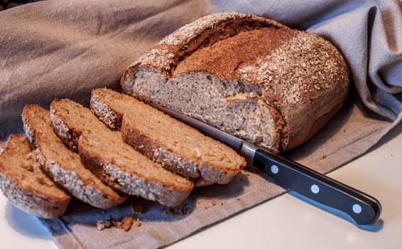 fresh grey bread cut by knife wrapped in cloth