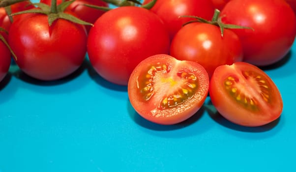 fresh ripe cherry tomatoes on blue background free space