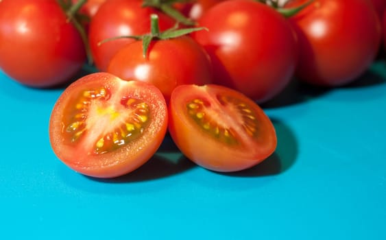 fresh ripe cherry tomatoes on blue background free space