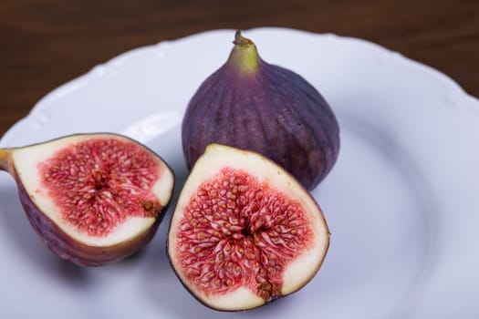 Fresh ripe figs on plate, exotic fruit close-up
