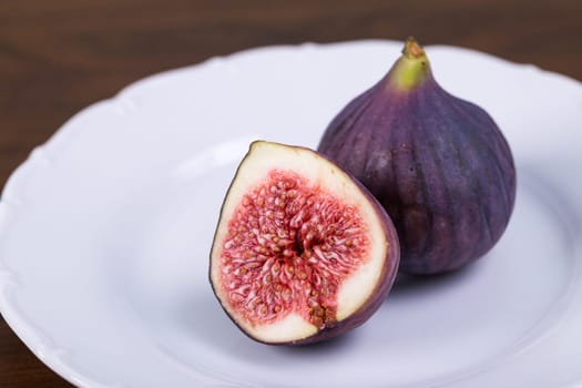 Fresh ripe figs on plate, exotic fruit close-up