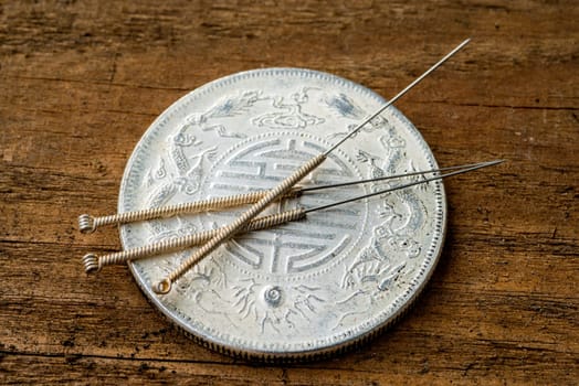Acupuncture needle on antique Chinese coin