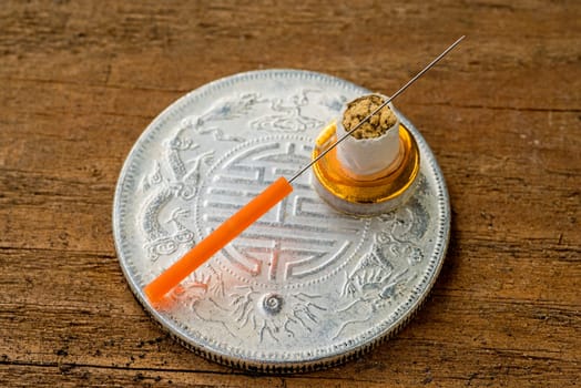 Acupuncture needle on antique Chinese coin
