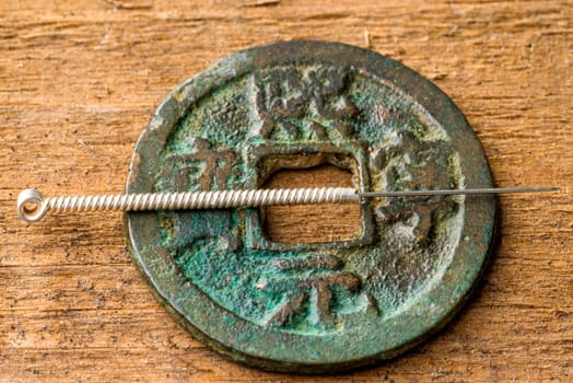 Acupuncture needle on antique Chinese coin