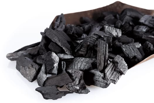 Pile of charcoal and shovel isolated on white