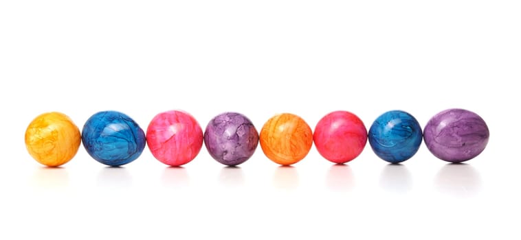 Eight colored eggs in a row on a white background, Easter header or background