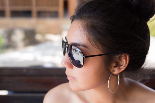 Asian woman wearing sun glasses and look at the outside